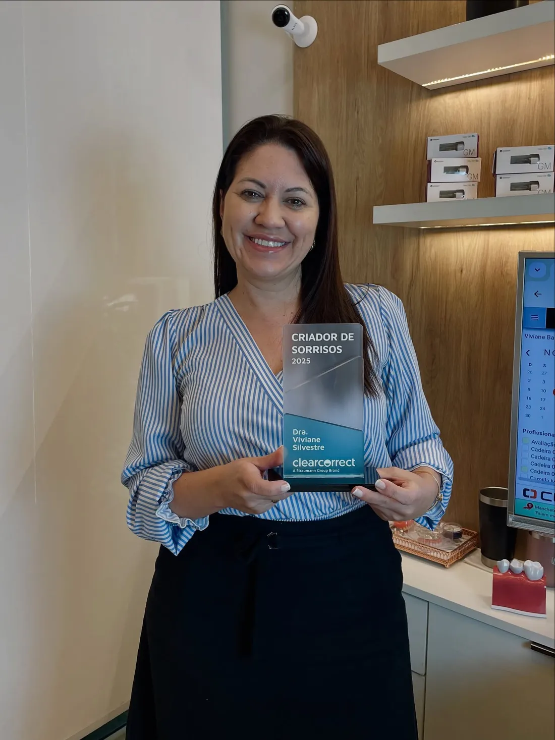 Dra. Viviane Silvestre sorrindo com o troféu Criador de Sorrisos 2025